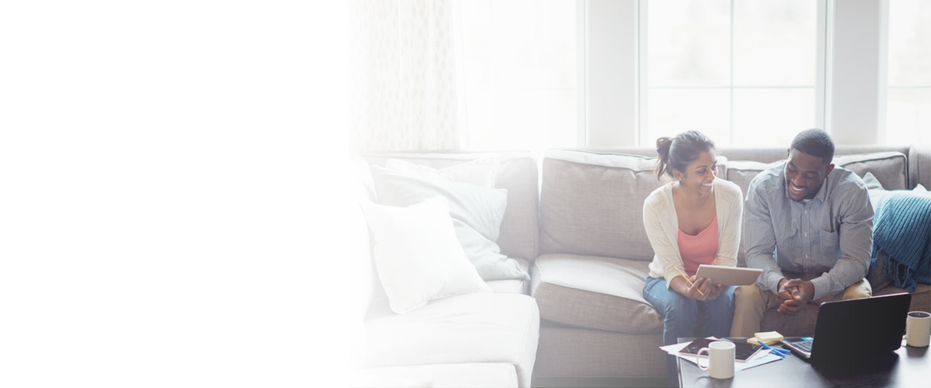 Man and woman sitting together on a sofa looking at a note